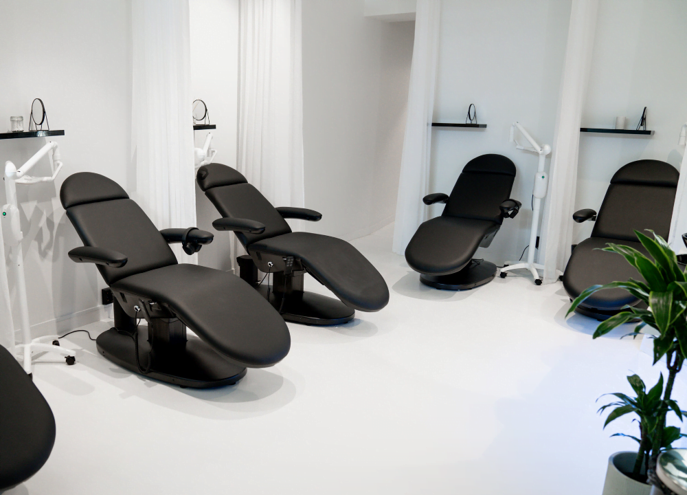 The UpWhiten studio seen from the entrance: black treatment chairs on a white floor.